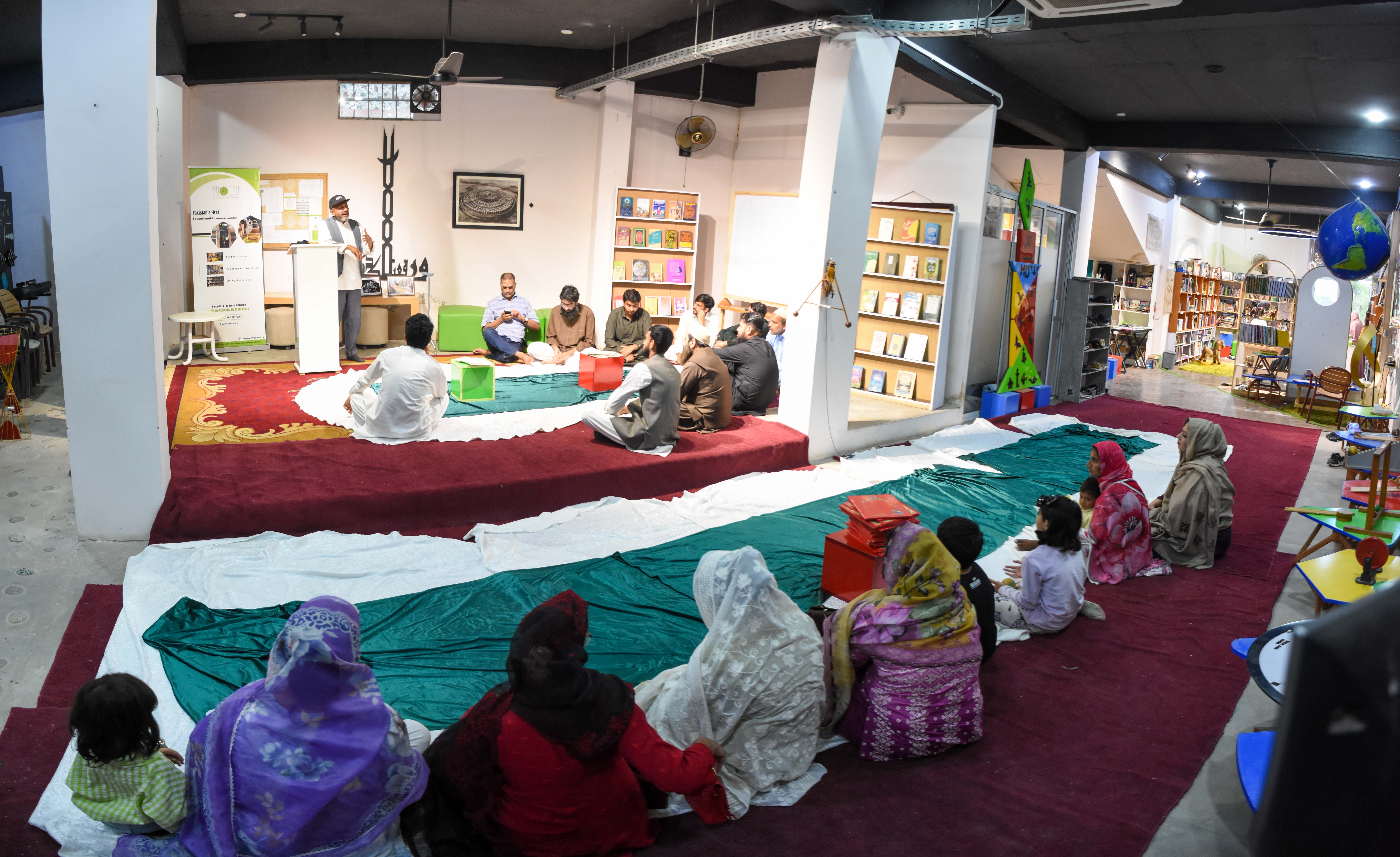 Quran Khwani — Women and children sit quietly on the floor cloth, listening attentively as the reciter leads the Quran Khwani from the front.